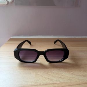 Designer black sunglasses, with metal badge logo